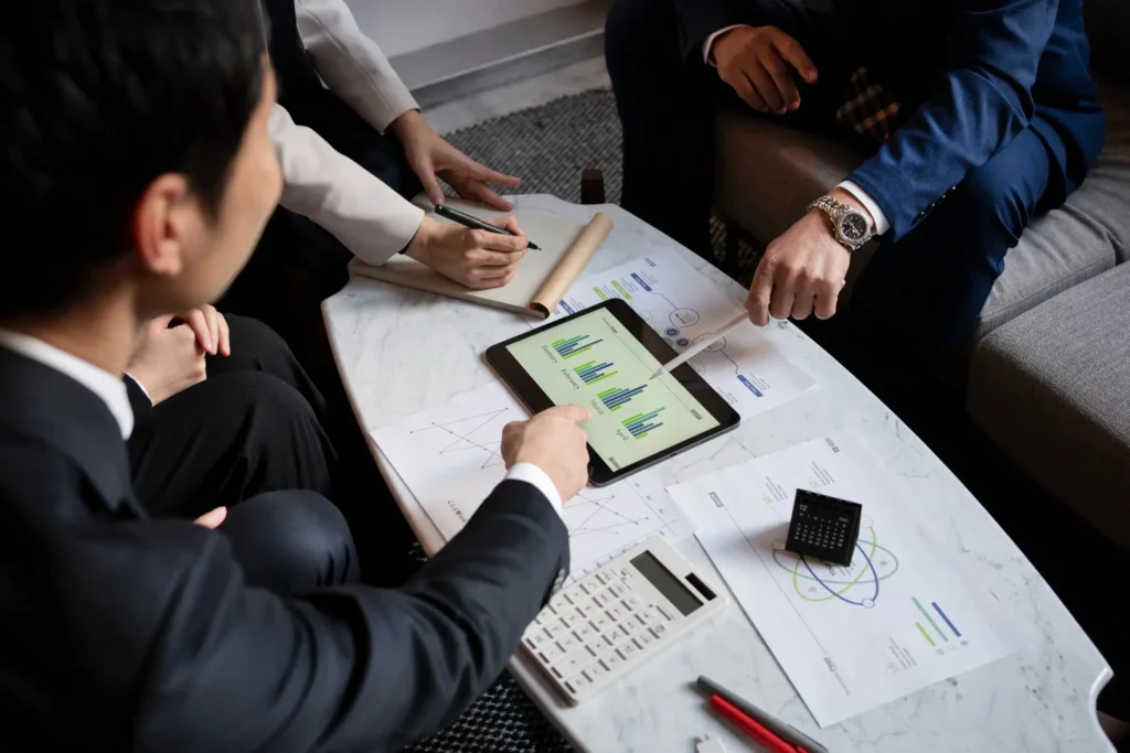 Hands pointing at table with papers and an iPad
