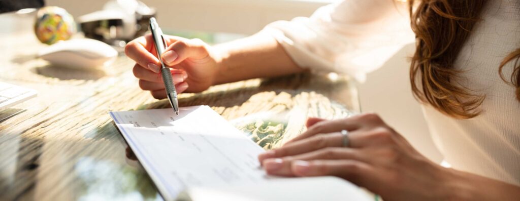 Female hand writing a check